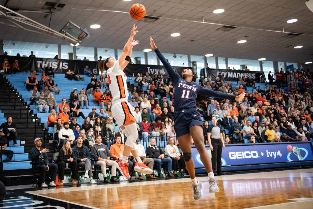 Princeton guard Kaitlyn Chen shoots a fadeaway jump shot near the baseline as a Penn defender extends her right arm to contest it.