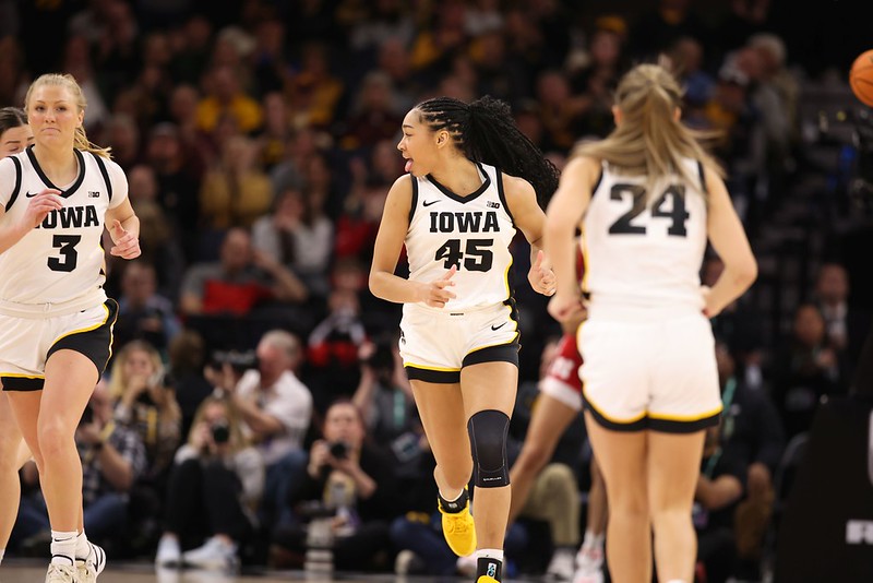 Iowa forward Hannah Stuelke smiles and runs down the court in the Big Ten championship game