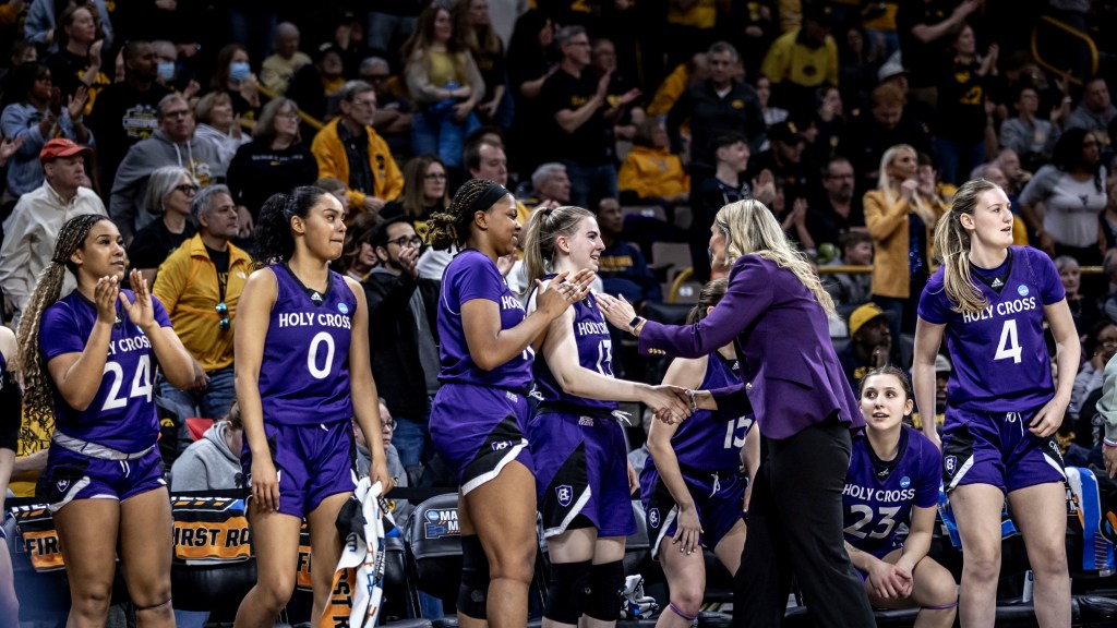  Holy Cross head coach Maureen Magarity smiles at her players on the sideline
