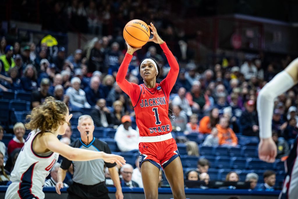 Ti'Ian Boler has the ball in her right hand in shooting position with two fingers of her left hand stabilizing the ball as she prepares to release it.