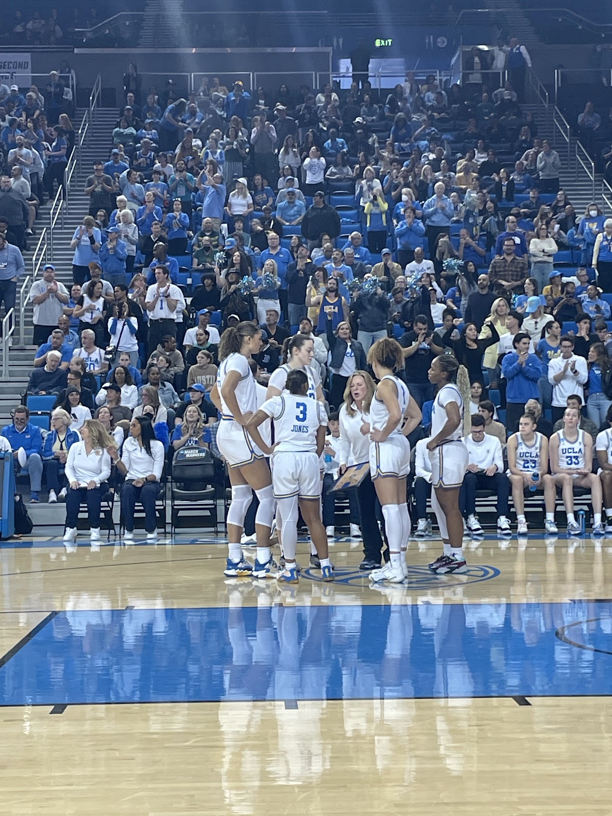 UCLA's starting lineup huddles with Coach Cori Close ahead of the team's matchup against Creighton.