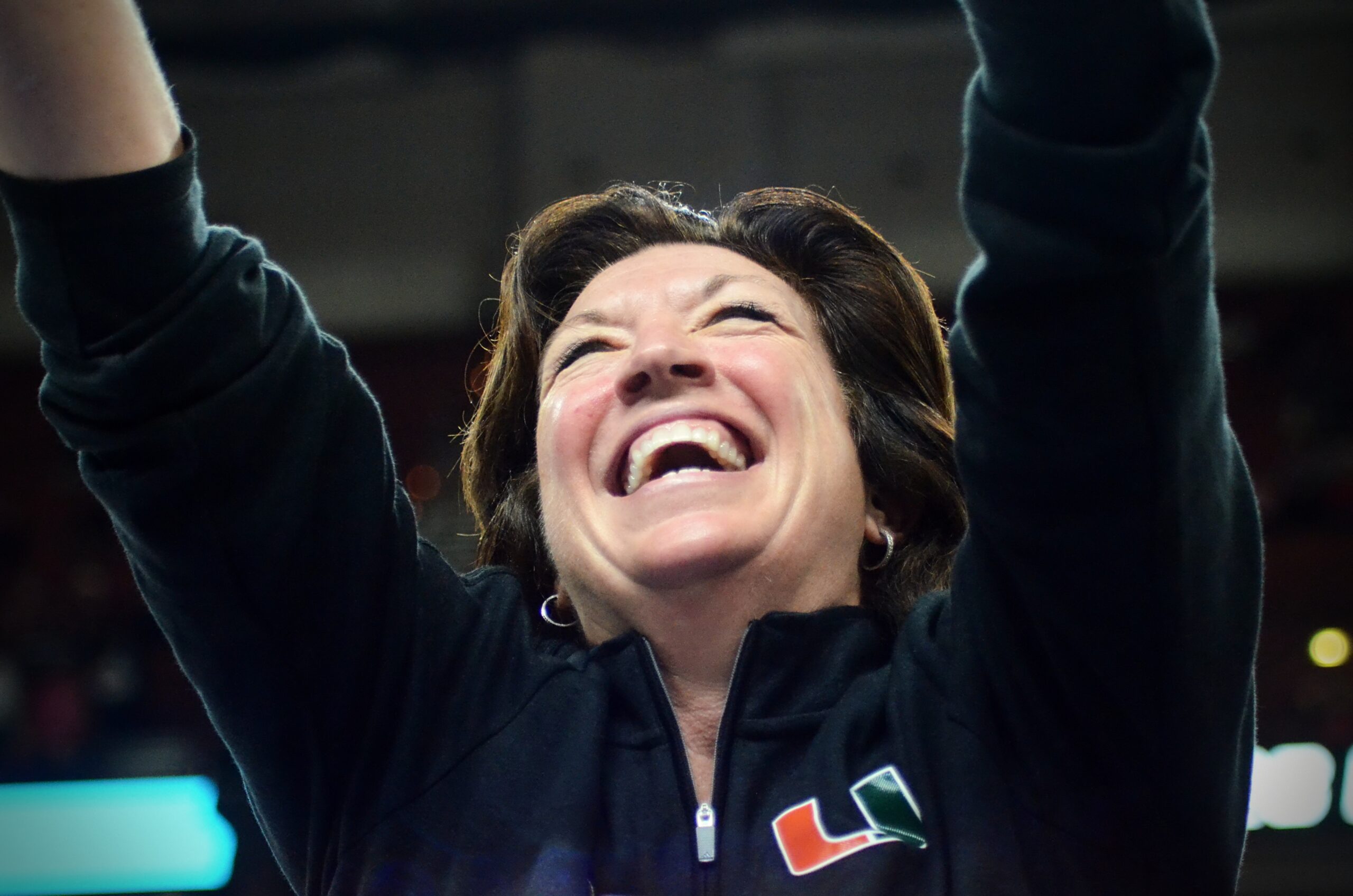 Miami head coach Katie Meier puts her arms in the air and smiles widely after a win in the 2023 Sweet 16.
