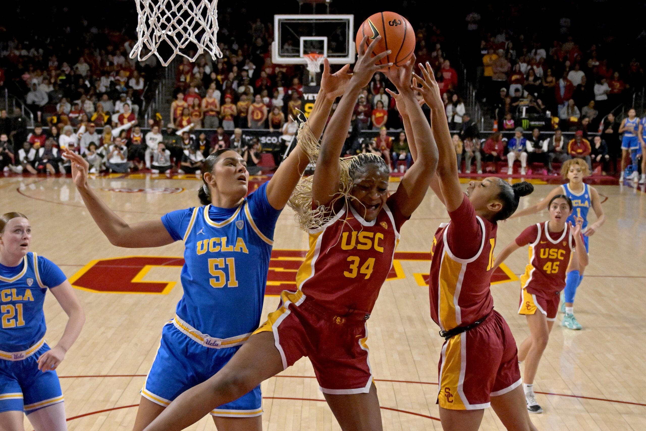 UCLA center Lauren Betts fights for a rebound against USC center Clarice Akunwafo and USC guard JuJu Watkins.