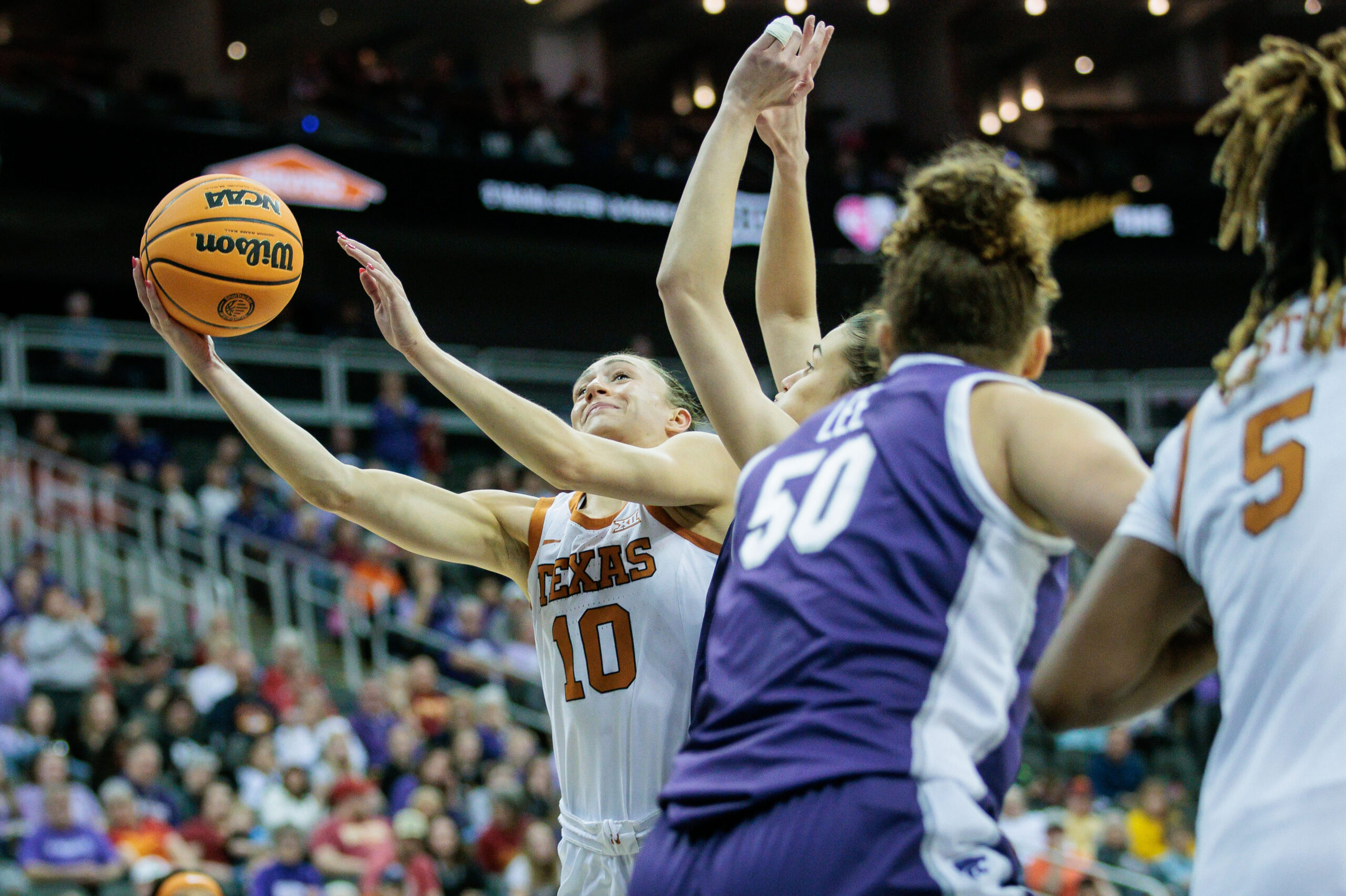 Texas guard Shay Holle shoots around Kansas State's Ayoka Lee during the Big 12 semifinals.