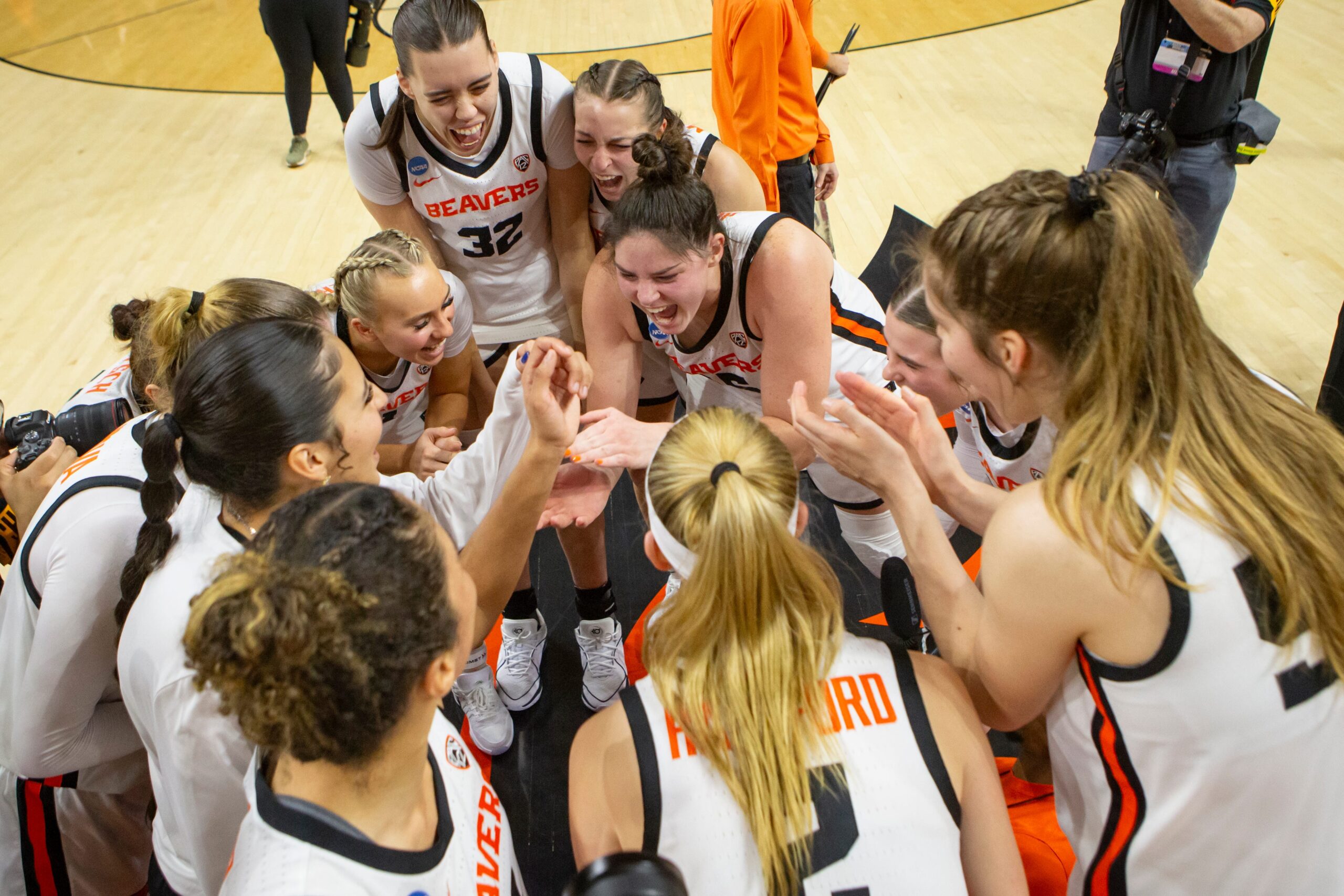 Oregon State players celebrate in a huddle following their NCAA Tournament second round victory