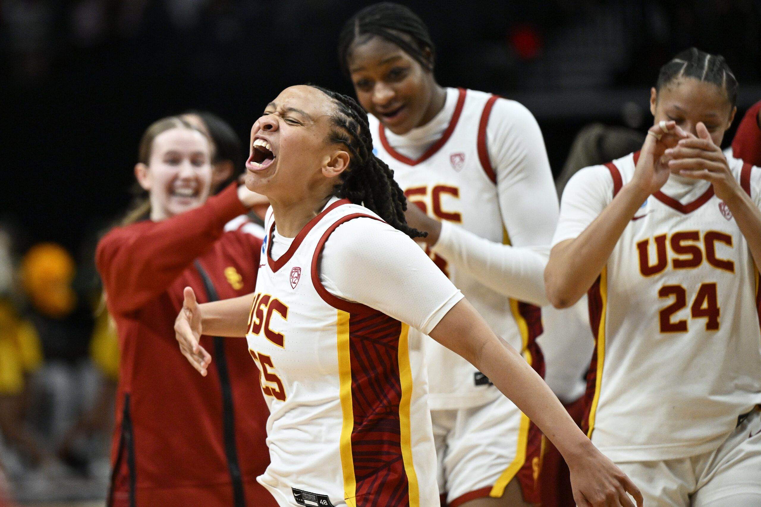 McKenzie Forbes screams in triumph and thumps her palm to her chest as her teammates cheer in the background.