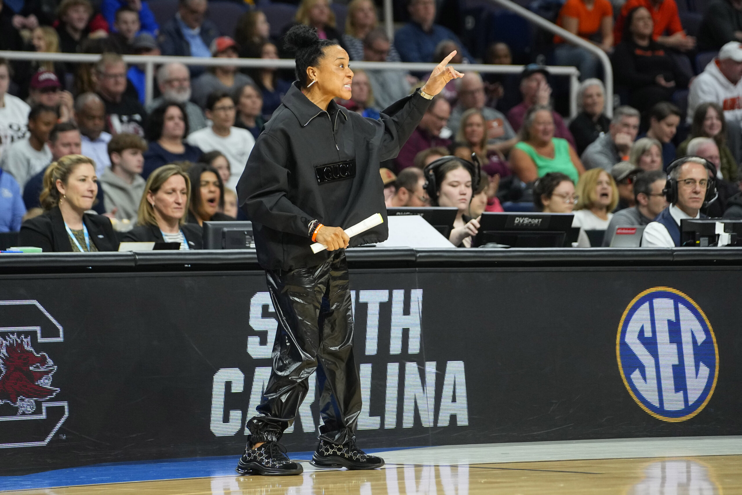 Photo of South Carolina coach Dawn Staley standing on a basketball court and directing her team.