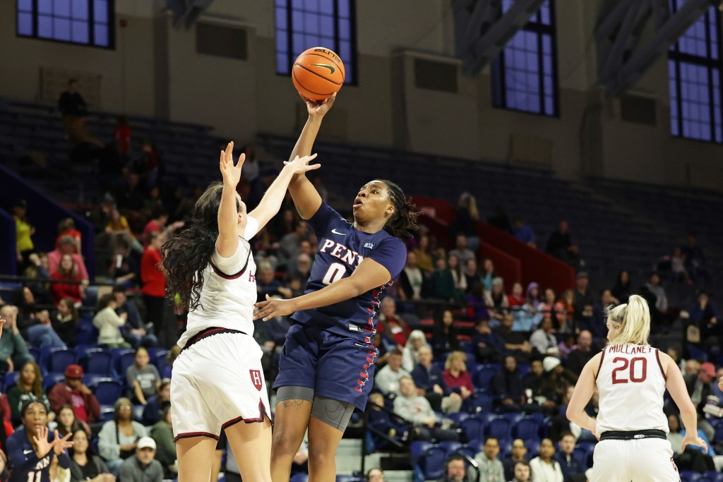 Penn forward Jordan Obi fades away as she shoots a jump shot over Harvard forward Katie Krupa, who reaches her left arm out to contest the shot.