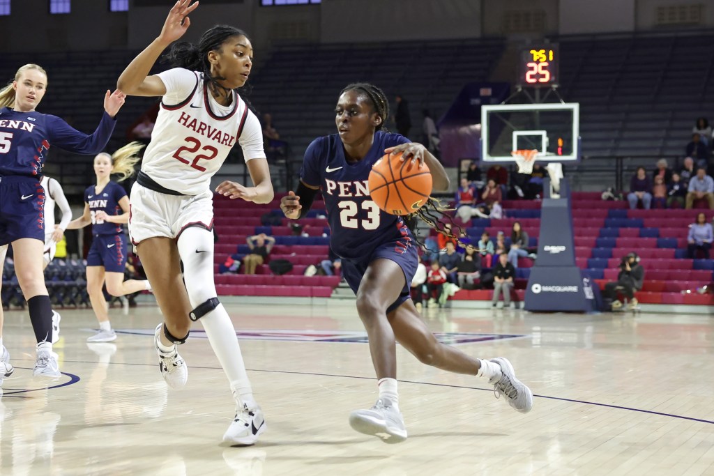 Penn guard Ese Ogbevire drives with her left hand on the left side of the basket as Harvard guard Saniyah Glenn-Bello attempts to close down the angle.