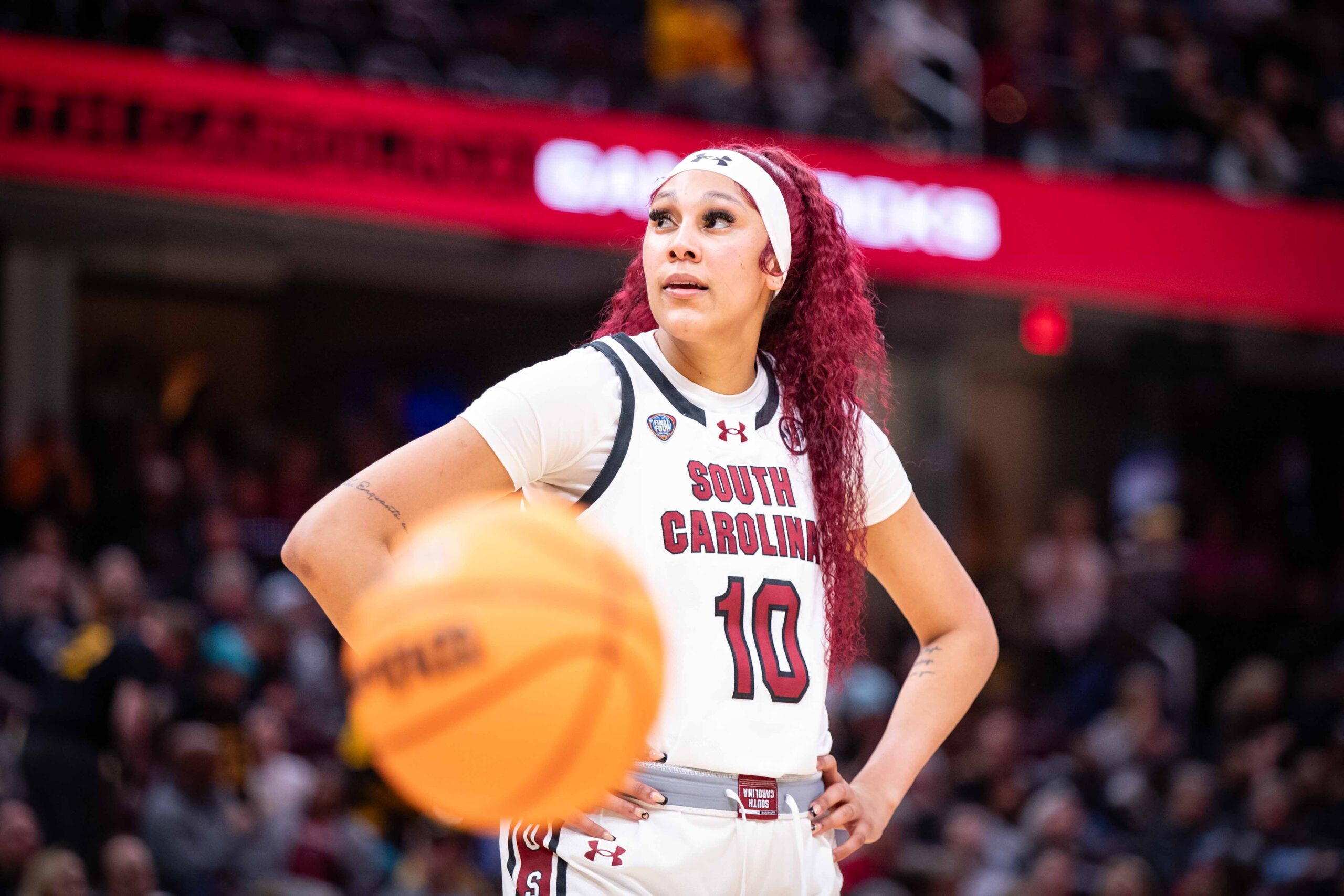 South Carolina center Kamilla Cardoso stands with her hands on her hips and looks up and to her right. The loose ball is visible in the foreground.