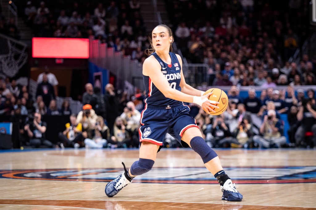 UConn guard Nika Mühl looks to make a pass from the top of the key.