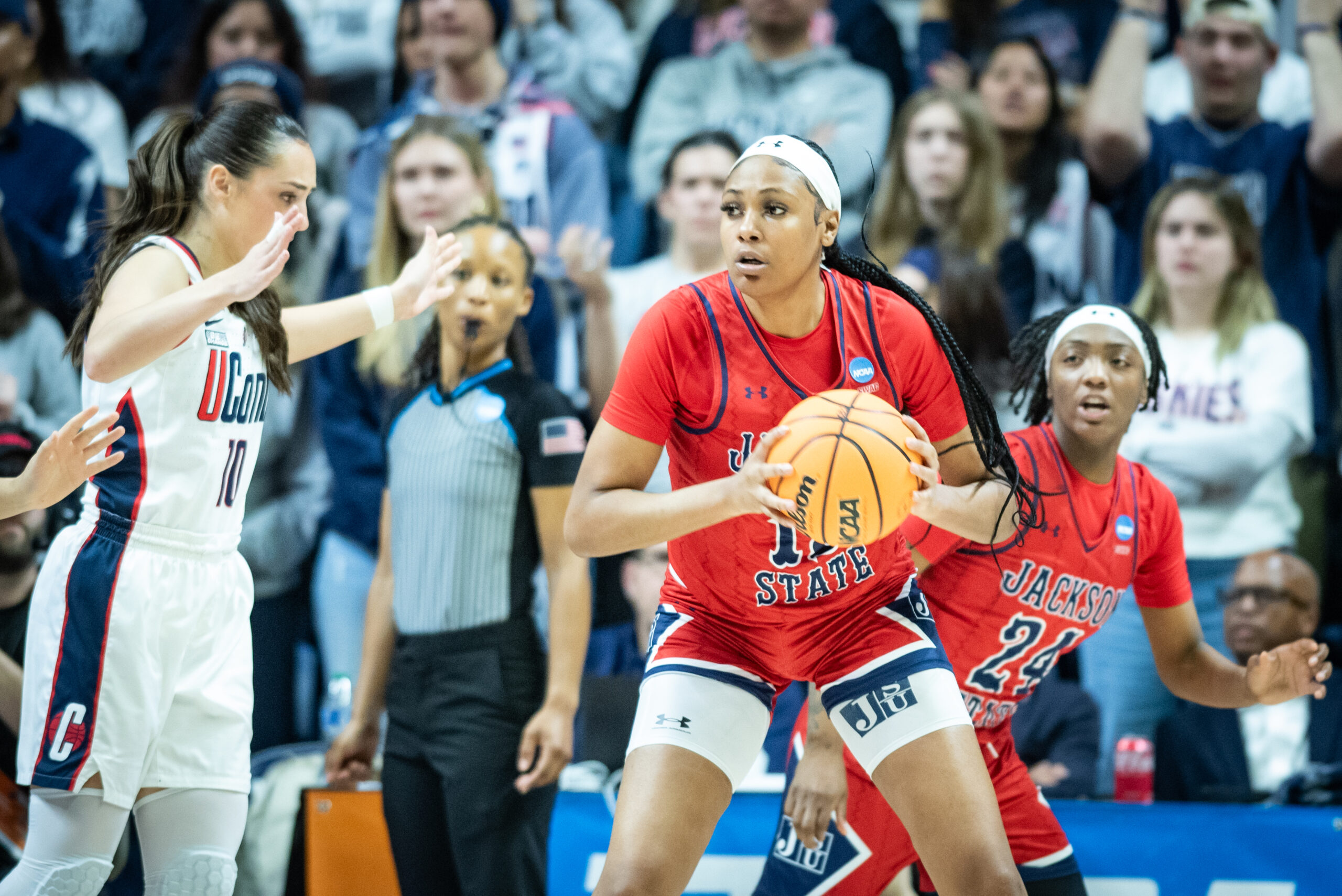 Jackson State center Angel Jackson holds the ball in front of her body with two hands and surveys her options.