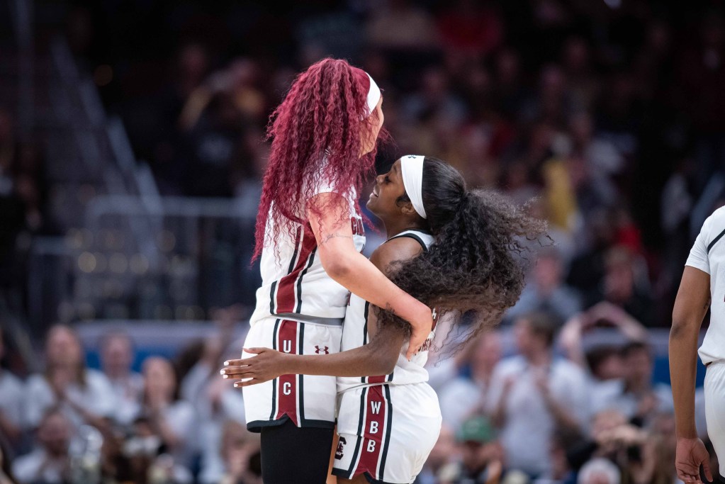 6'7 South Carolina center Kamilla Cardoso embraces her 5'9 teammate Raven Johnson.
