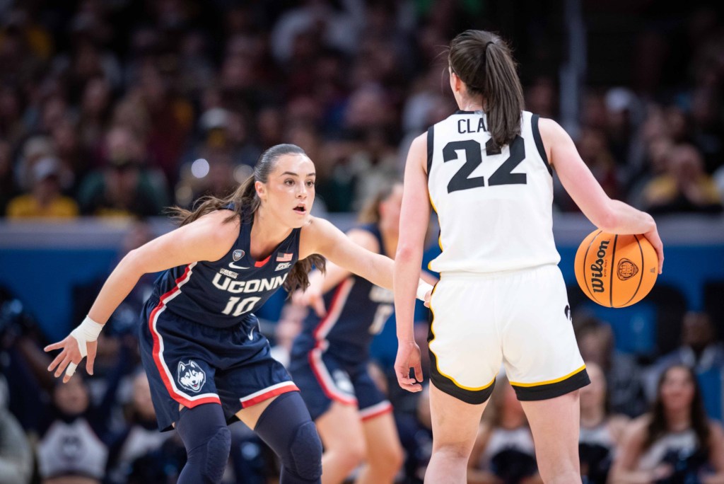 Nika Mühl crouches in a defensive stance with her arms out as she defends Caitlin Clark