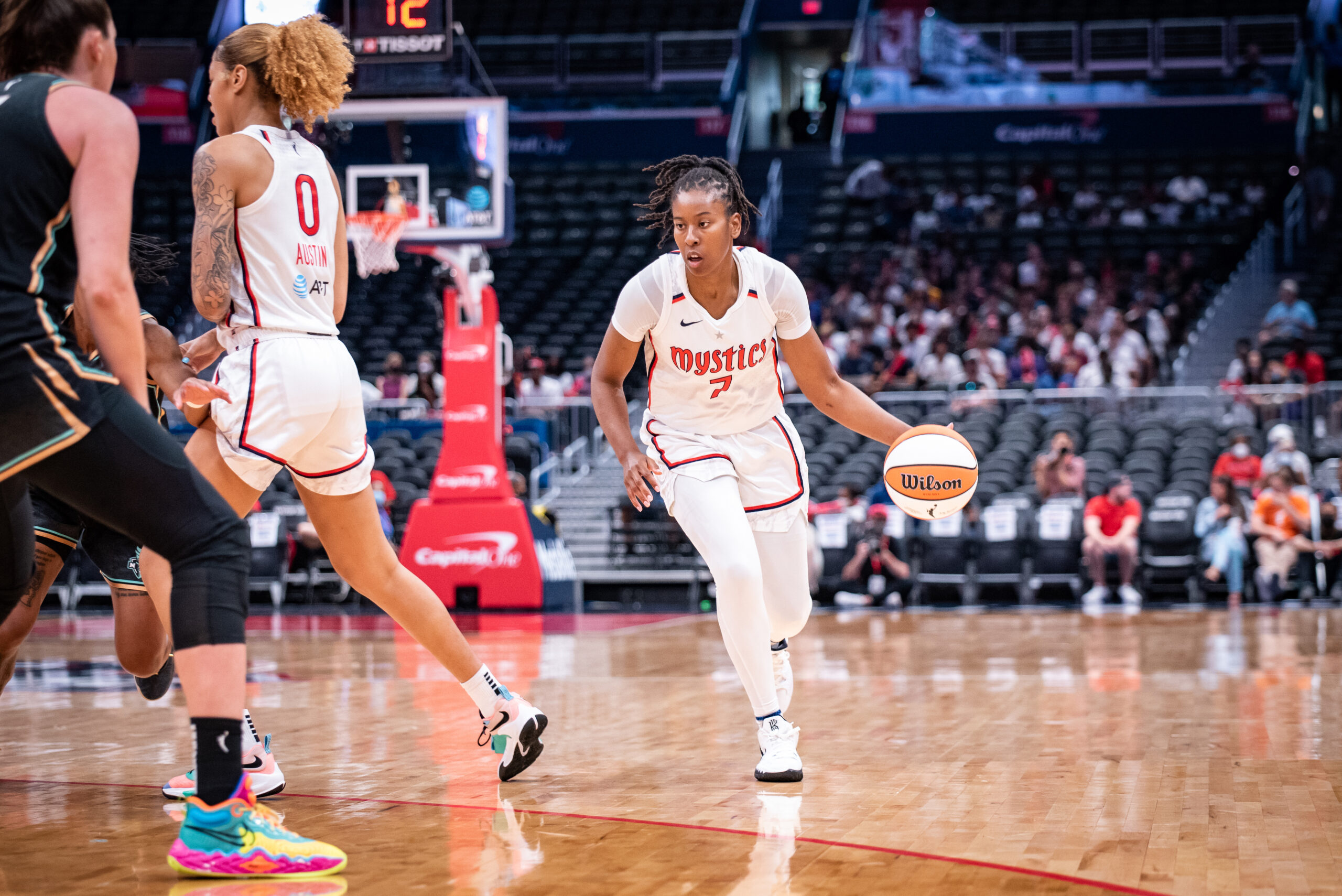Washington Mystics guard Ariel Atkins dribbles with her left hand toward the rim. Center/forward Shakira Austin sets a screen for her, facing the middle of the court.