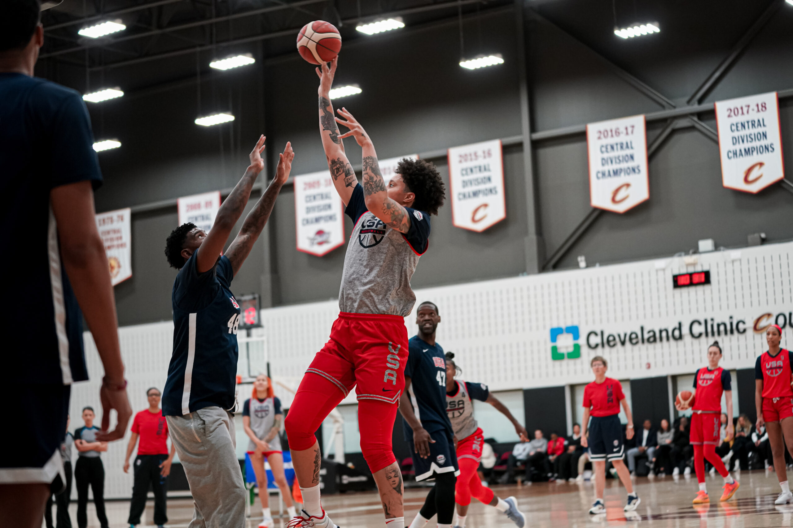 Team USA center Brittney Griner shoots a right-handed fadeaway shot over a male practice player.