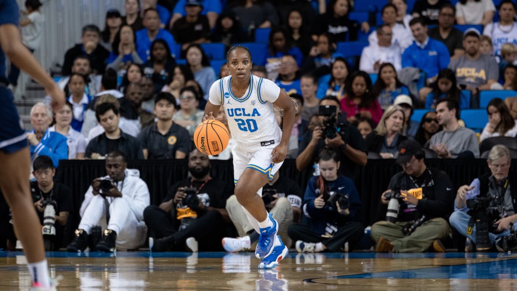 UCLA guard Charisma Osborne dribbles the ball up the court.