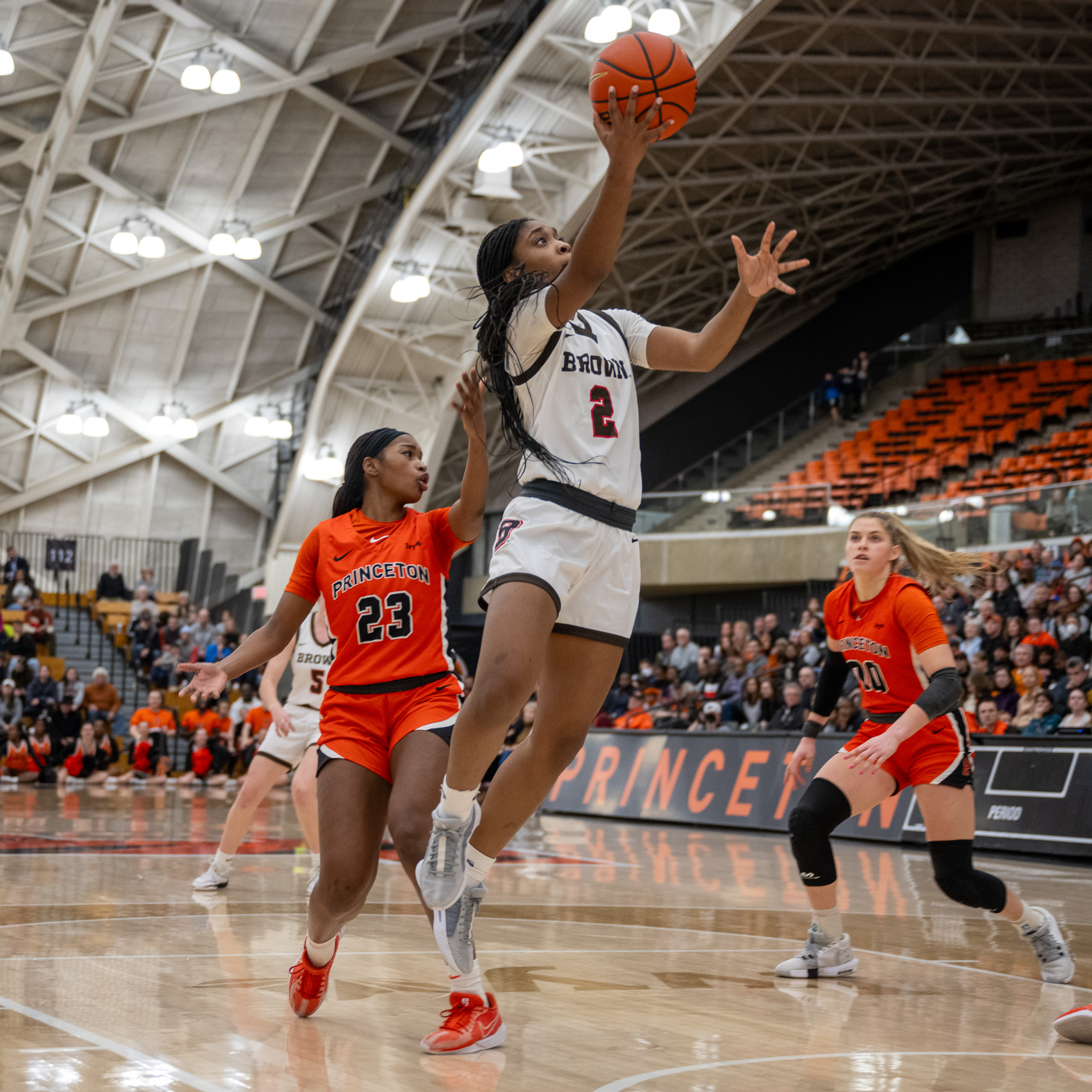 Brown guard Kyla Jones shoots an open right-handed layup as two Princeton defenders look on.