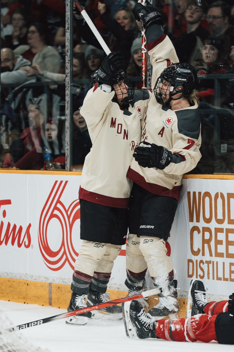 Laura Stacey celebrates a goal against Ottawa with Marie-Philip Poulin. They are hugging while looking at each other. Poulin is on the left and Stacey is on the right. Both are in cream away uniforms.