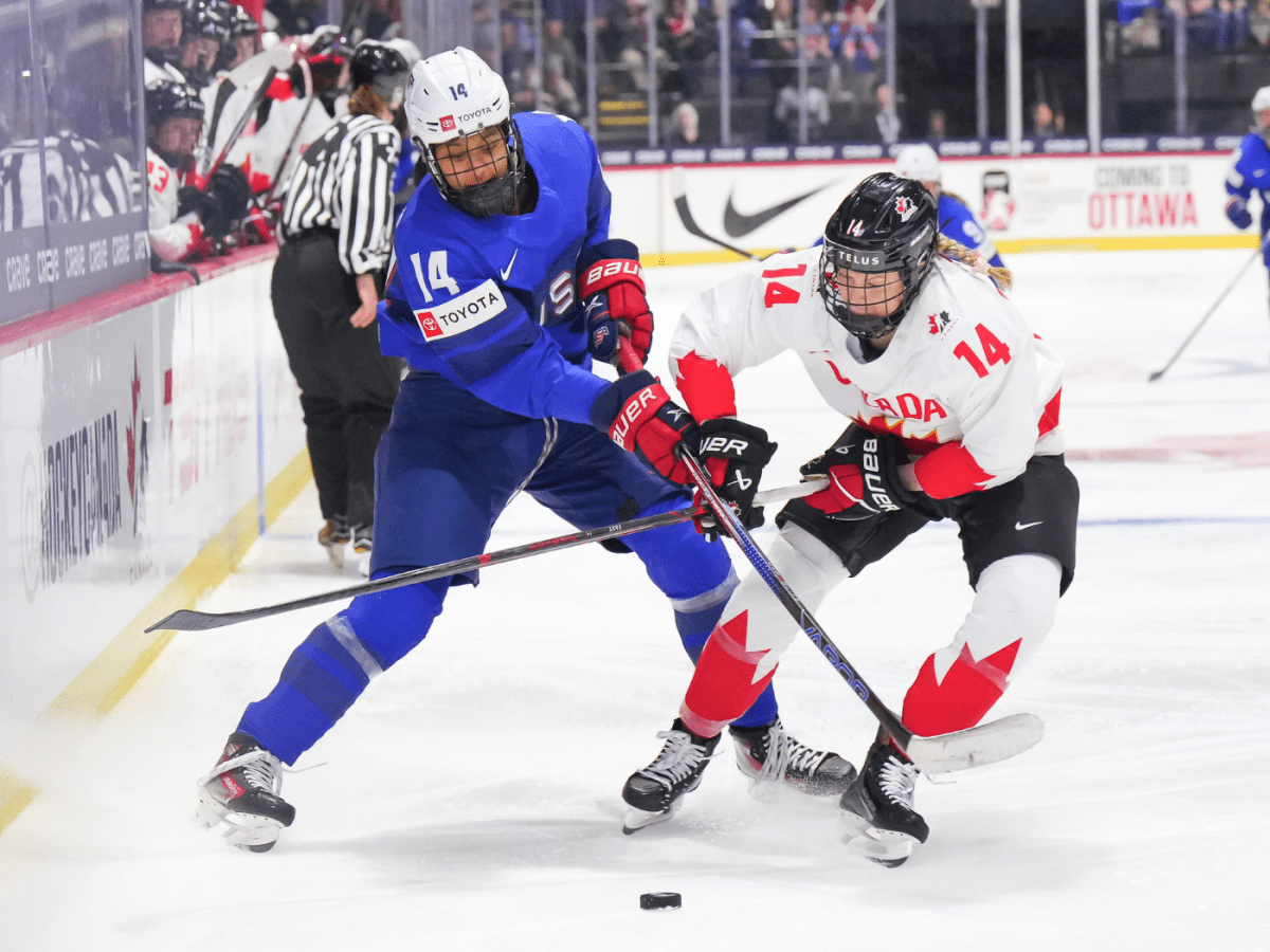 Edwards (left) and Fast (right) battle over the puck. Their sticks are crossed and the puck sits between them.