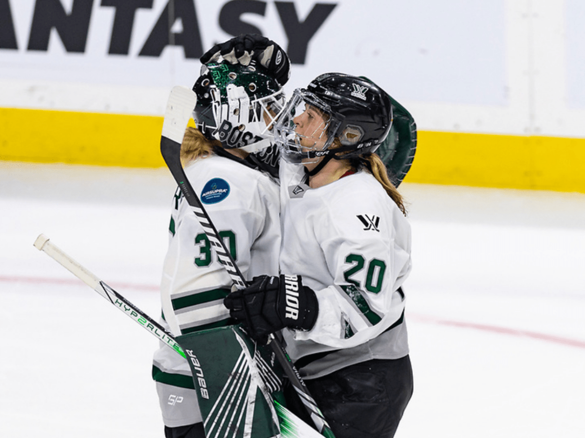 Brandt (right) hugs Söderberg (left) postgame and gives her a head tap. They are in white away uniforms.