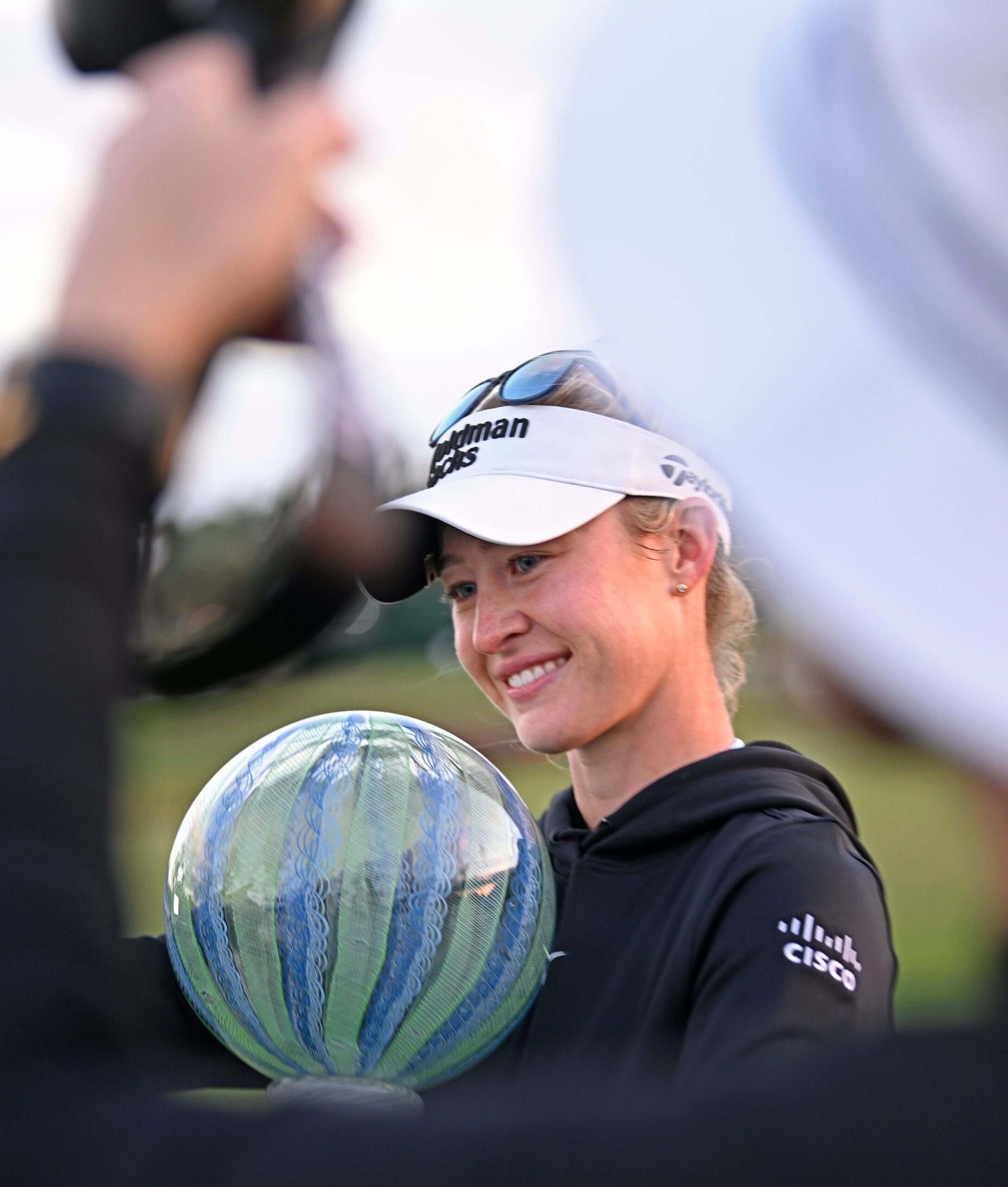 Nelly Korda holds a trophy and smiles