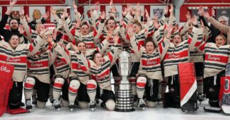Ohio State women's hockey team celebrates a championship in front of a trophy