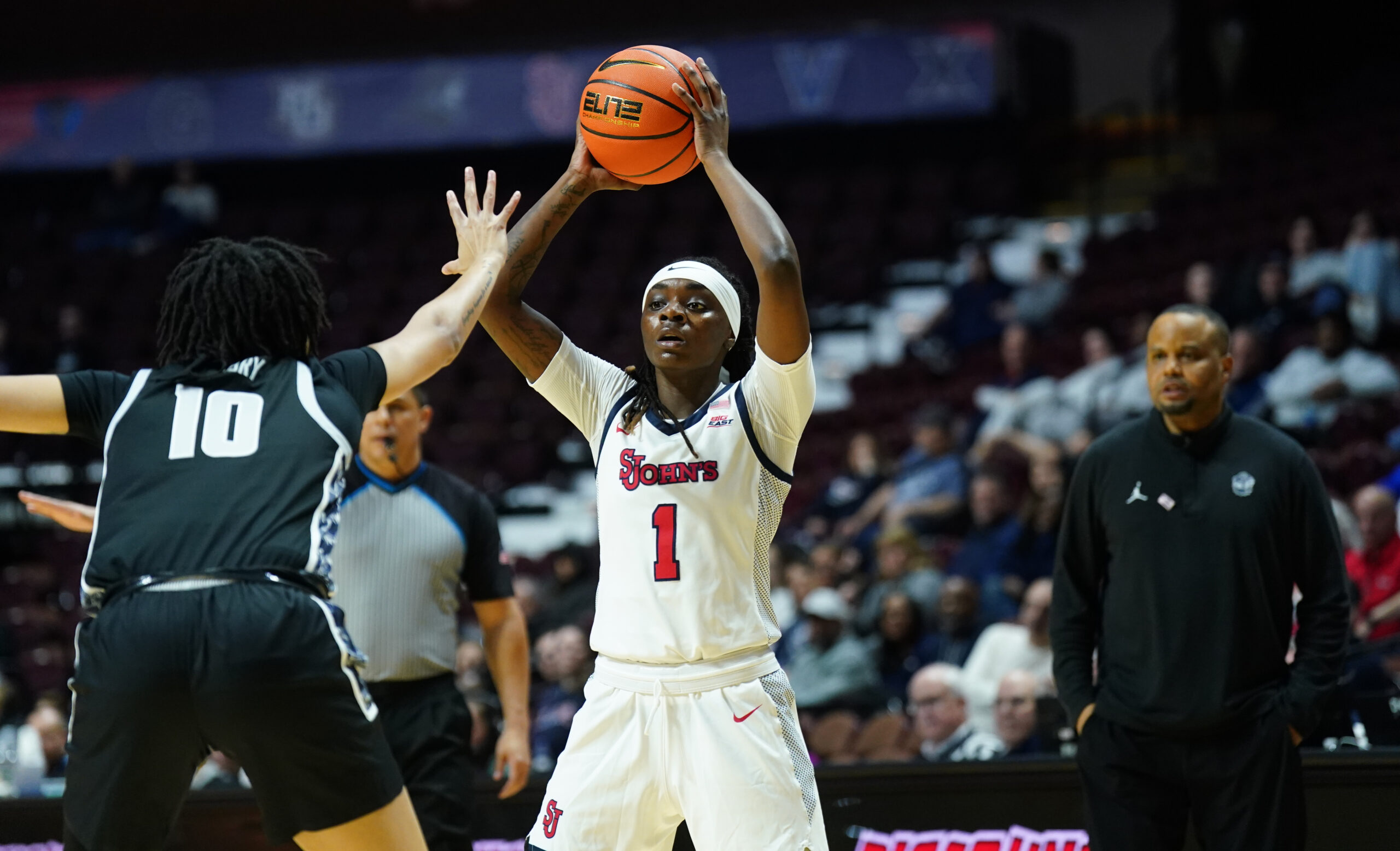 Unique Drake holds the basketball over her head, looking for an outlet pass over a Georgetown defender.