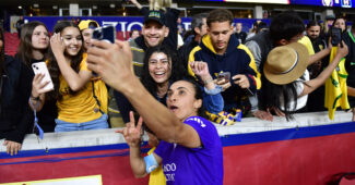 Marta takes a selfie with fans after a match
