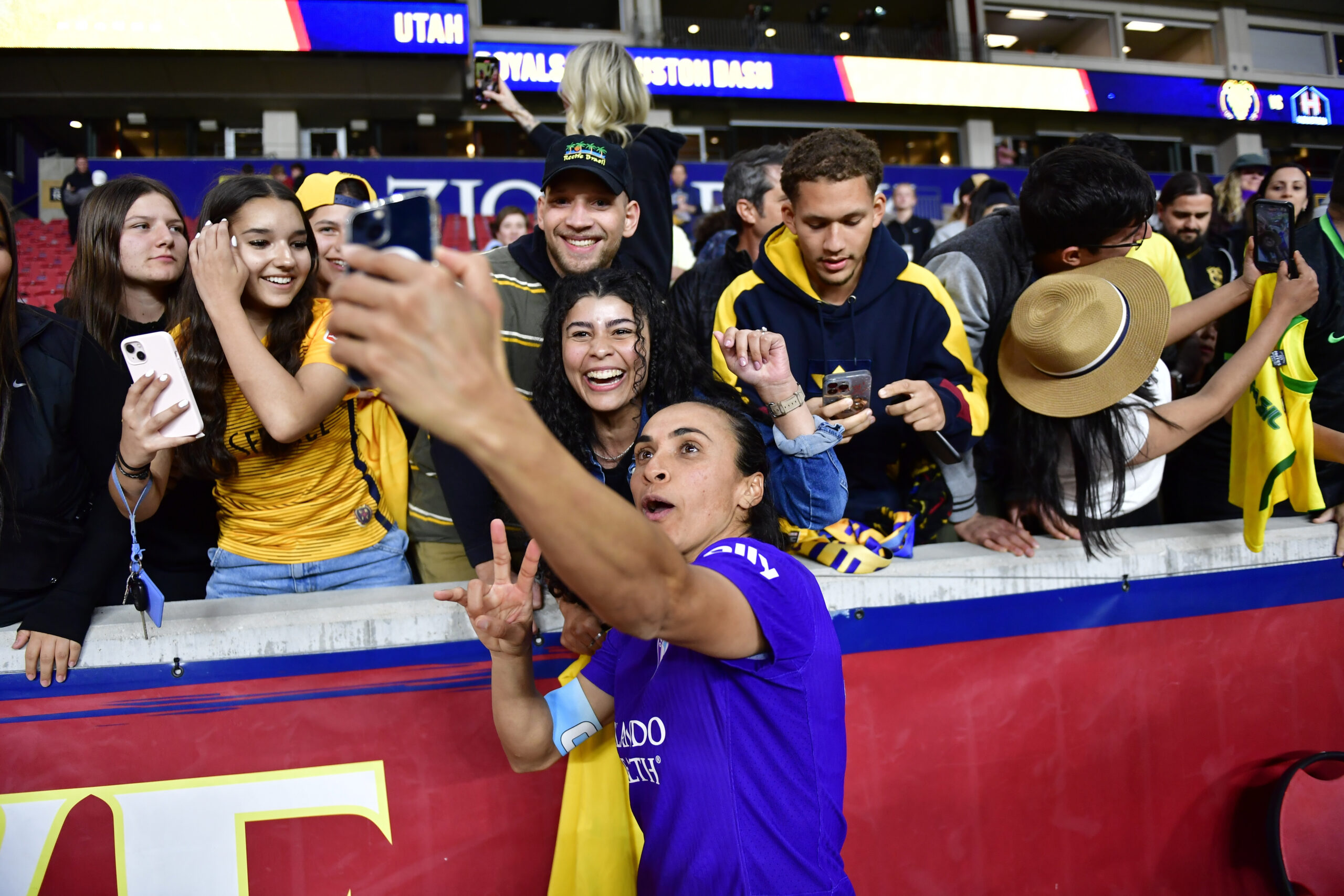 Marta takes a selfie with fans after a match