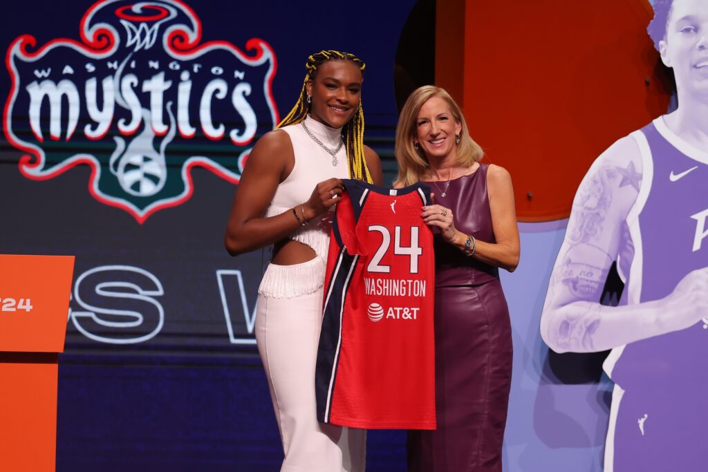 Aaliyah Edwards and Cathy Engelbert pose with Edwards' new uniform at the 2024 WNBA Draft.
