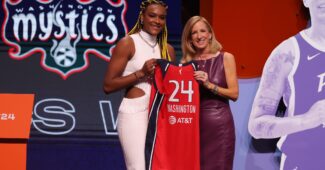 Aaliyah Edwards and Cathy Engelbert pose with Edwards' new uniform at the 2024 WNBA Draft.