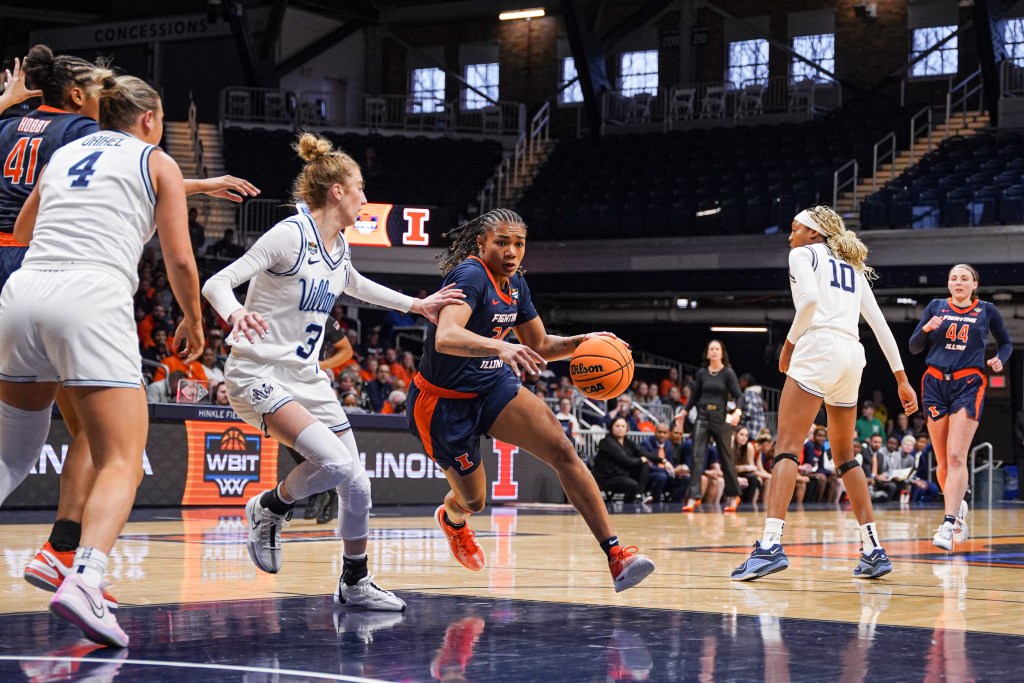 Illinois guard Adalia McKenzie dribbles the ball into the paint with her left hand as a defender tries to cut her off.