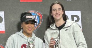 Dawn Staley and Caitlin Clark pose with trophies.