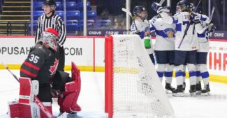 Finland teammates celebrates a goal behind the net vs. Canada