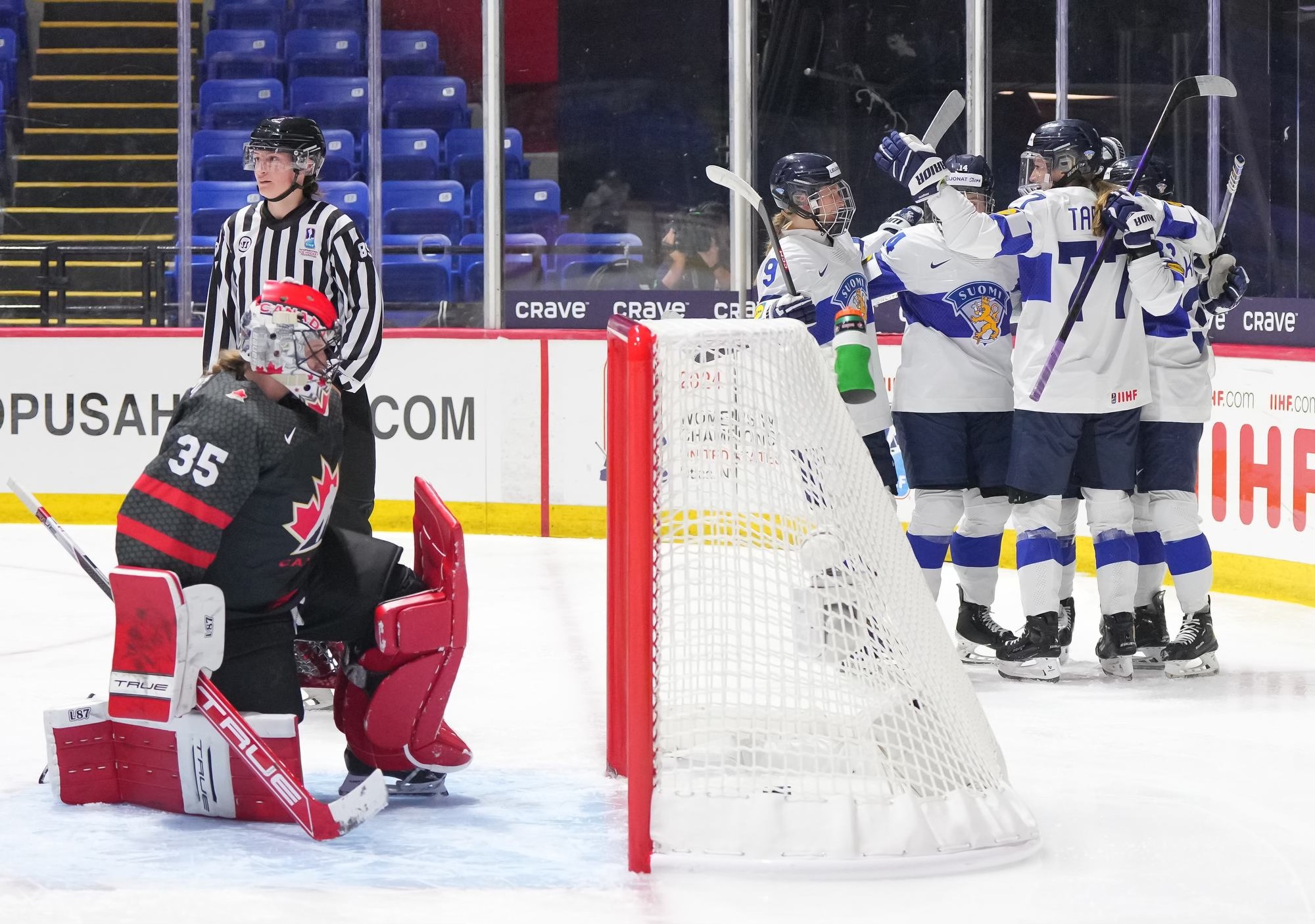 Finland teammates celebrates a goal behind the net vs. Canada