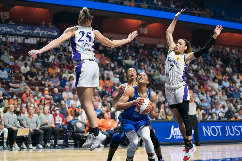 Los Angeles Sparks guard Chennedy Carter and forward Amy Atwell jump for blocks before Connecticut Sun forward Alyssa Thomas has left her feet to shoot.