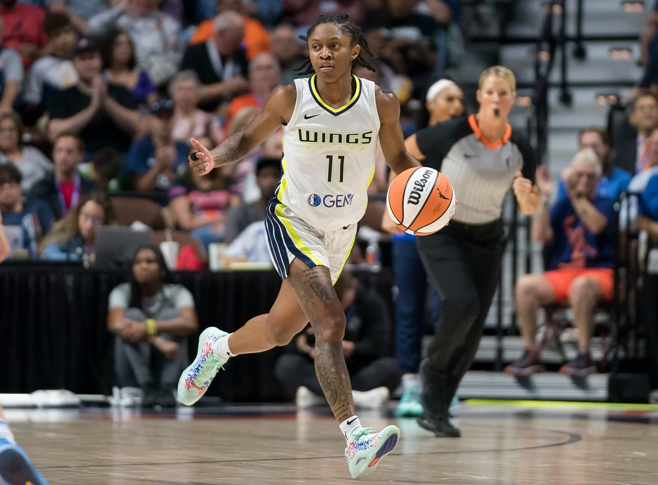 Dallas Wings guard Crystal Dangerfield has her eyes up as she dribbles the ball with her left hand.