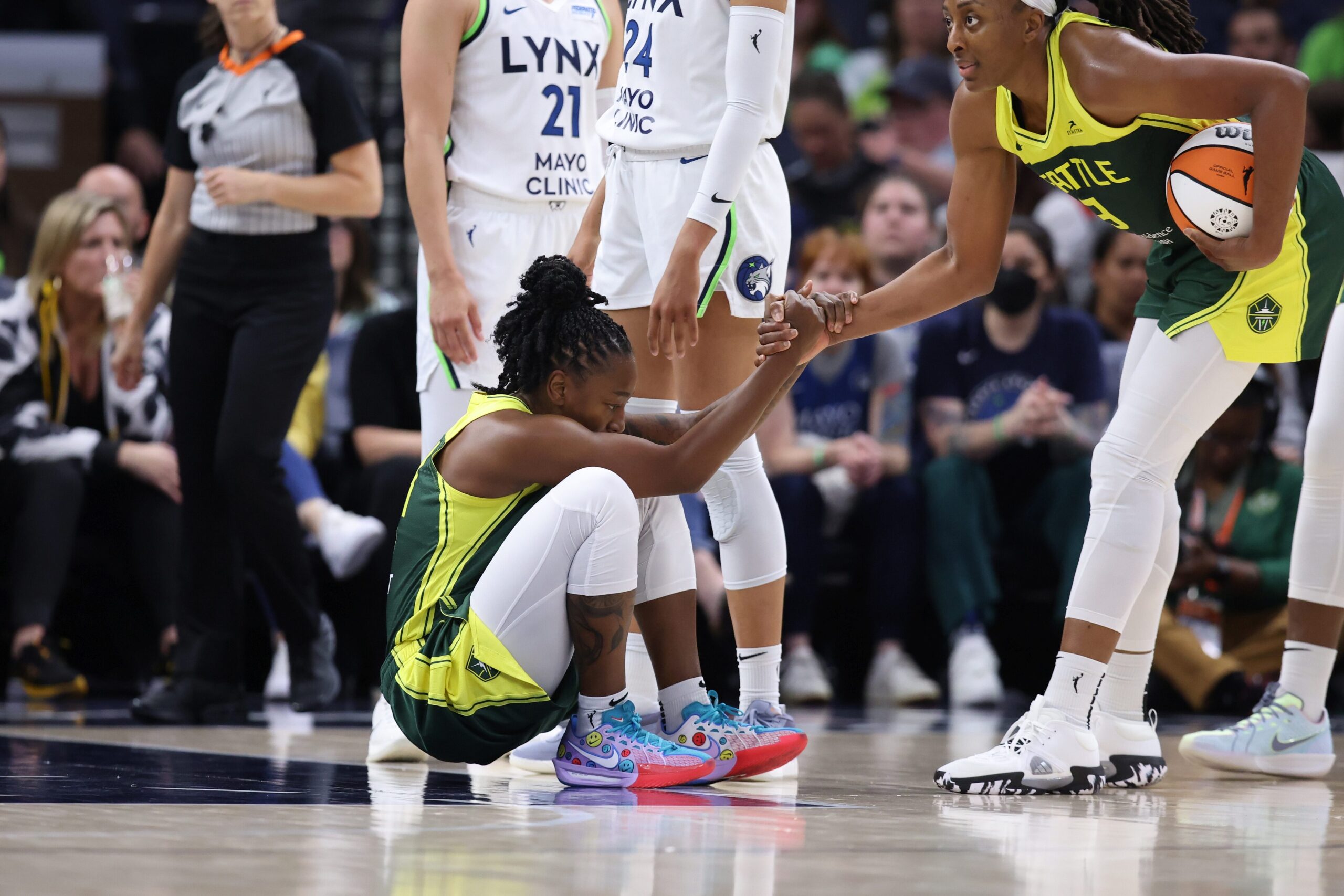 A teammate helps Jewell Loyd stand up on the court. Loyd is wearing her new player-edition sneakers.