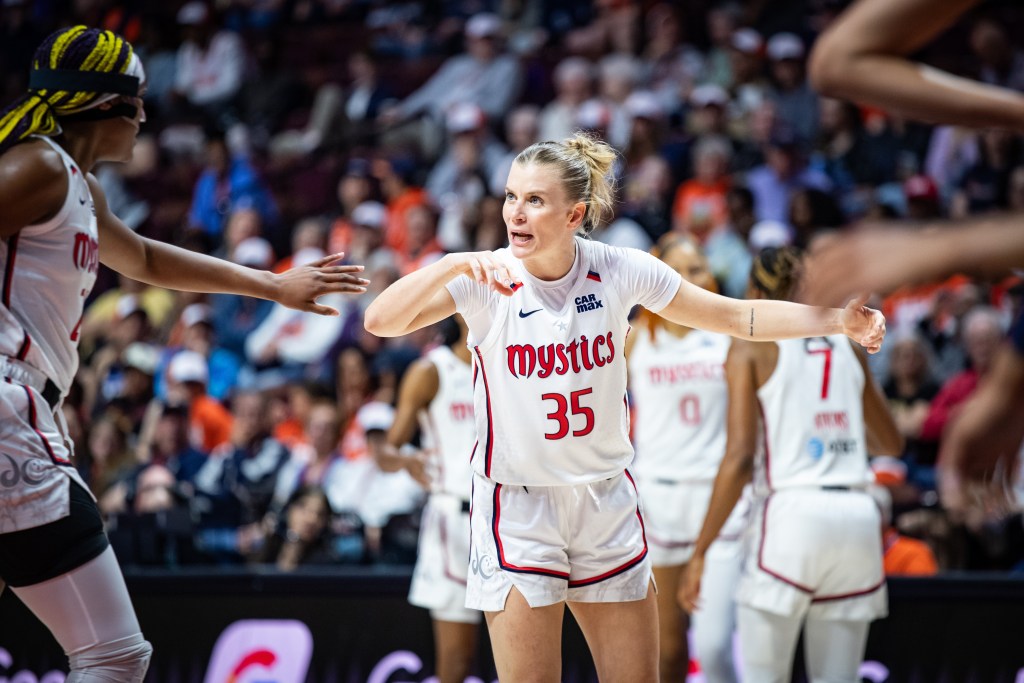 Washington Mystics guard Julie Vanloo looks at teammate Aaliyah Edwards and says something to her. Edwards reaches her arm out for a high five.
