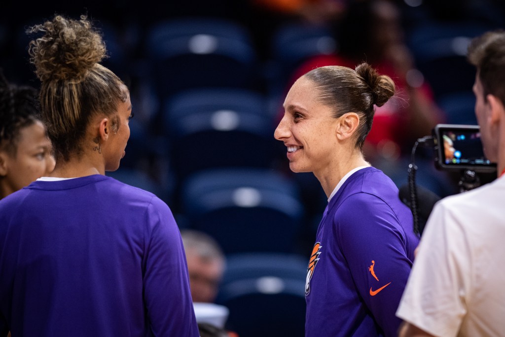 Phoenix Mercury guard Diana Taurasi smiles talking to teammates 