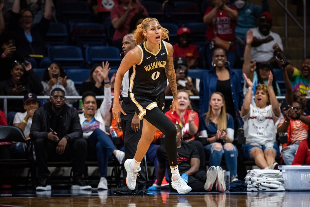 Washington Mystics center/forward Shakira Austin runs down the court as the home crowd cheers behind her. She appears to be saying something, but no other players are in the frame.