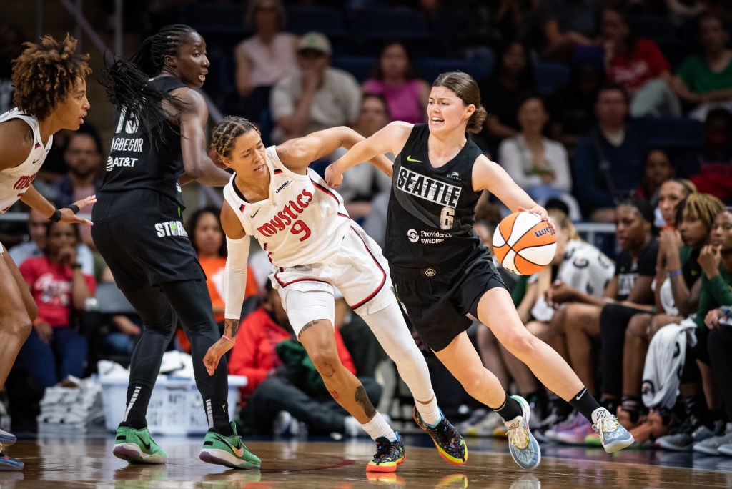 Seattle Storm guard Jade Melbourne dribbles the ball with her left hand as she tries to attack to her left. Washington Mystics guard Natasha Cloud is off balance coming around a screen but stays with Melbourne.