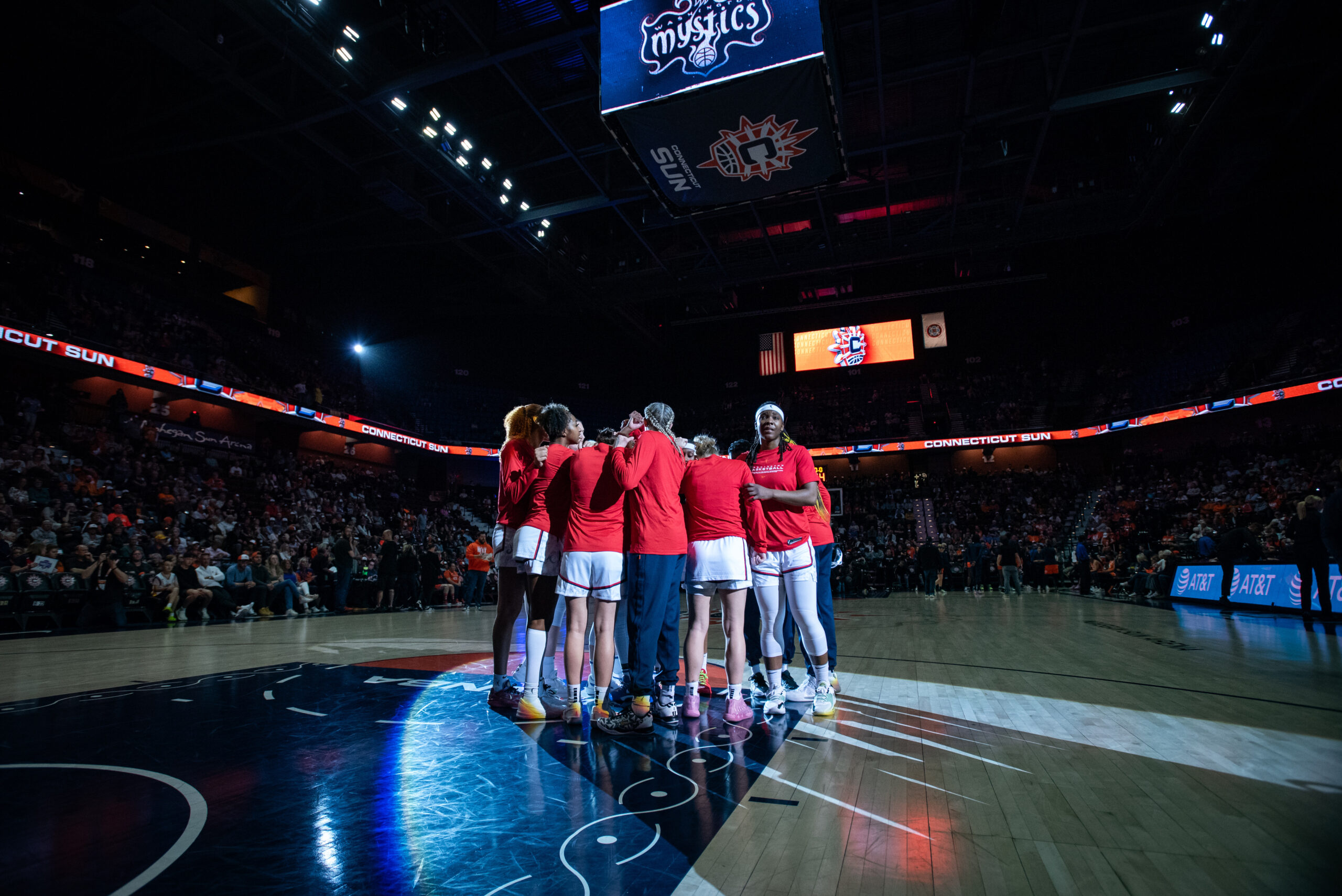 Washington Mystics players huddle near the free-throw line before a game.