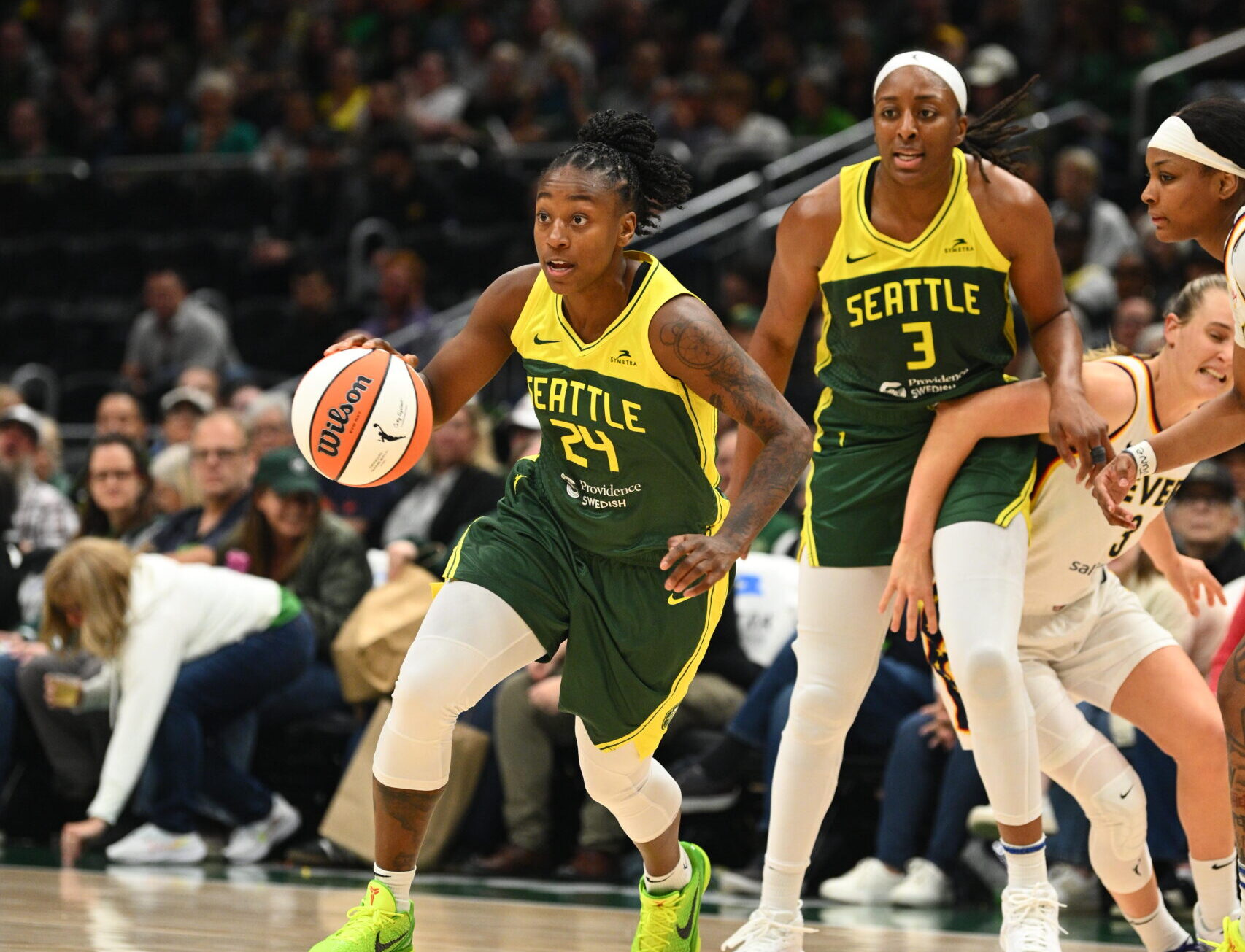 Seattle Storm guard Jewell Loyd drives with the basketball as forward Nneka Ogwumike stands behind her. Ogwumike has just set a screen that two Indiana Fever defenders are trying to get around as they chase Loyd.