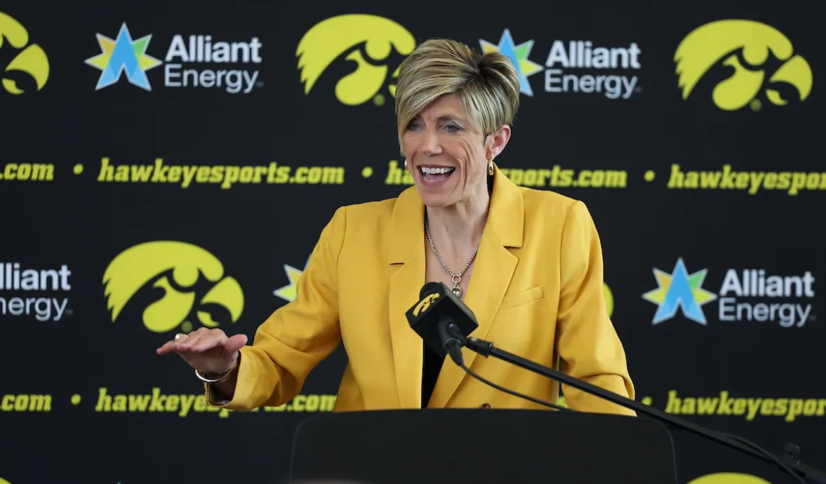 Iowa head coach Jan Jensen sits at the podium and speaks during her introductory press conference.