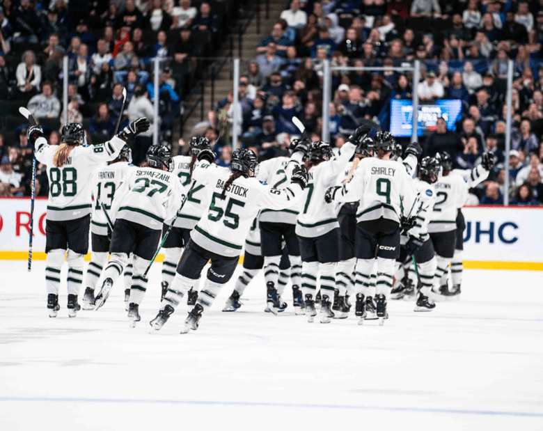 The entire Boston team skates after Müller while celebrating their Game 4 win. They are wearing white away uniforms.