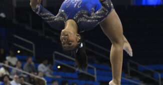 UCLA's Selena Harris is shown in midair as she flips backward on balance beam.