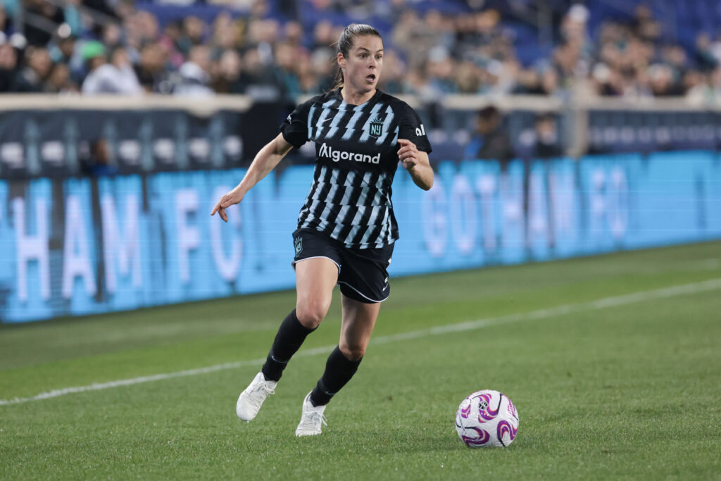 Kelley O’Hara dribbles the ball in a black Gotham FC kit