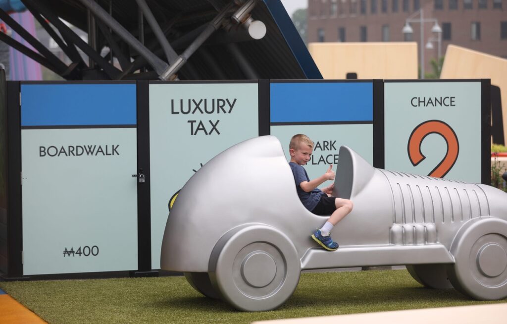 A little boy in a Monopoly car.